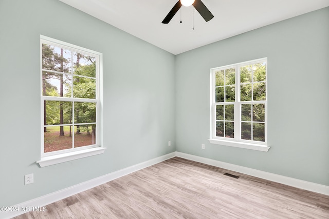 unfurnished room with light hardwood / wood-style flooring, plenty of natural light, and ceiling fan