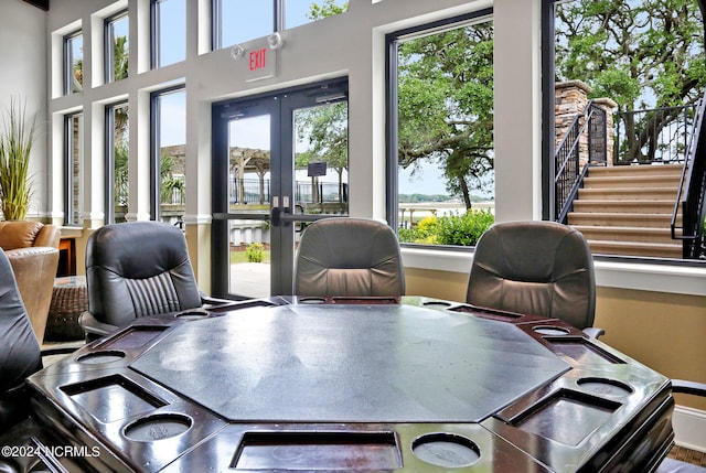 office area featuring french doors, a healthy amount of sunlight, and a water view