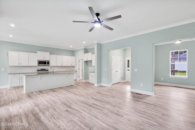 unfurnished living room featuring ornamental molding, sink, light wood-type flooring, and ceiling fan