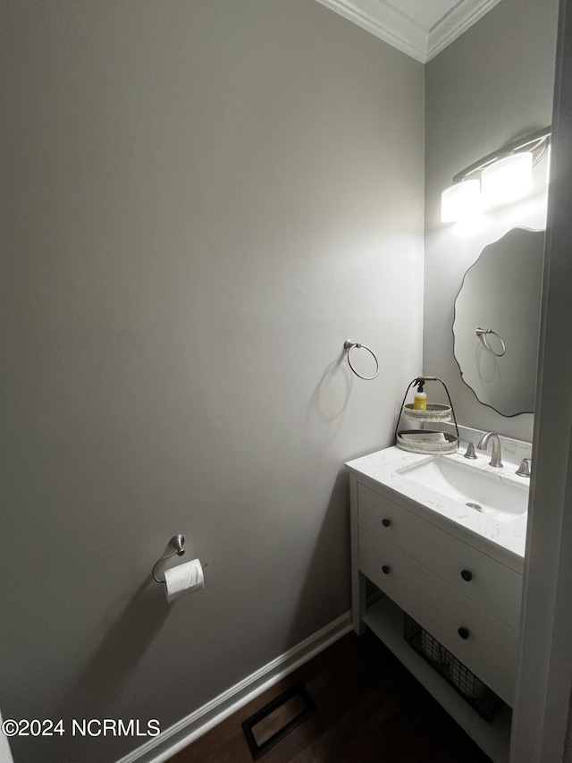 bathroom with vanity, ornamental molding, and hardwood / wood-style flooring