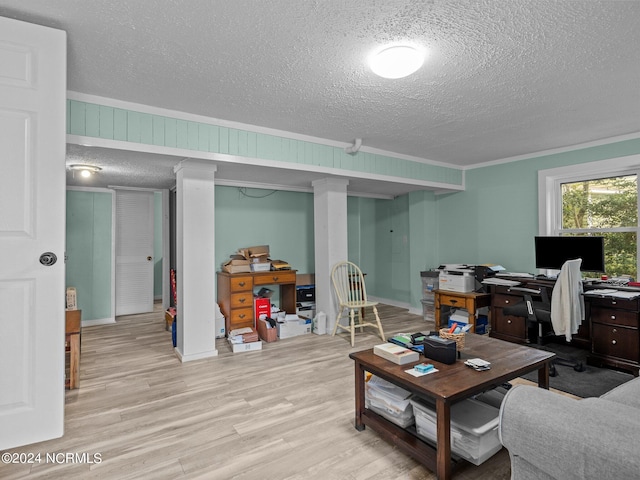 living room featuring light hardwood / wood-style floors, crown molding, and a textured ceiling