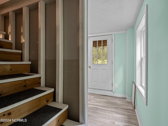 staircase featuring hardwood / wood-style flooring and a textured ceiling