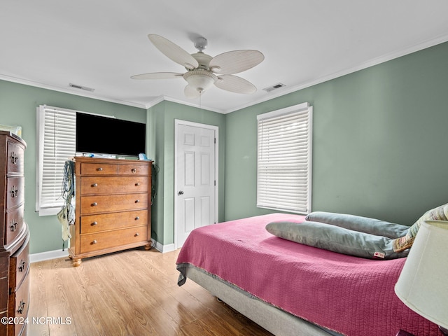 bedroom featuring ornamental molding, wood-type flooring, and ceiling fan