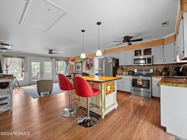 kitchen with white cabinets, ceiling fan, appliances with stainless steel finishes, sink, and butcher block countertops