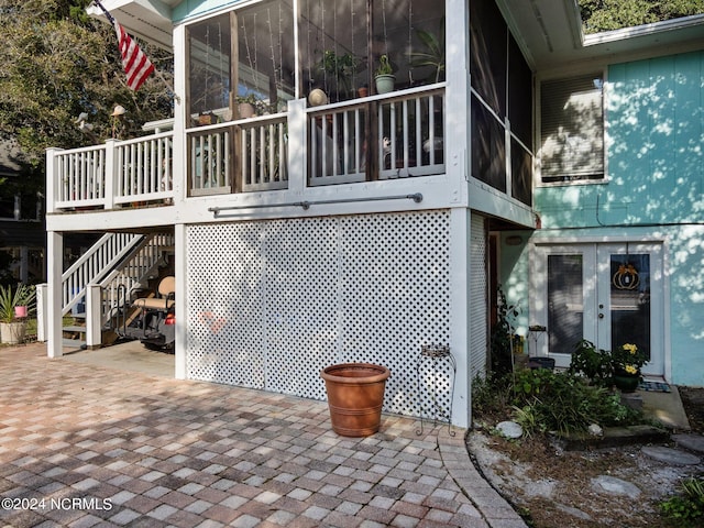 view of side of home with a patio area and a sunroom