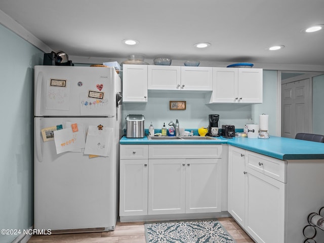 kitchen featuring white cabinetry, light hardwood / wood-style flooring, sink, and white refrigerator