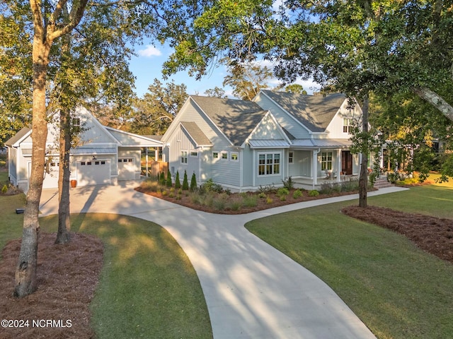 view of front of home with covered porch, a front yard, and a garage