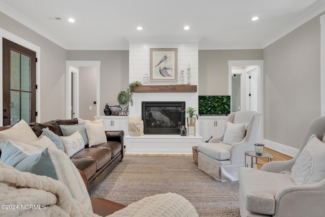 living room with crown molding, light hardwood / wood-style floors, and a fireplace