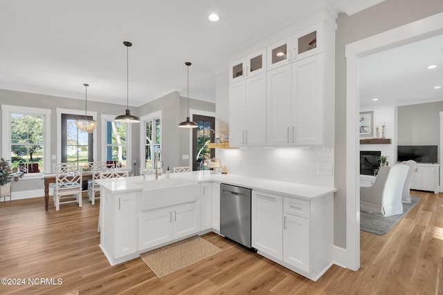 kitchen featuring dishwasher, light wood-type flooring, sink, white cabinetry, and pendant lighting