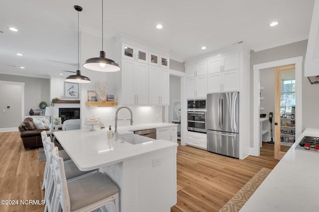 kitchen featuring sink, appliances with stainless steel finishes, light hardwood / wood-style flooring, and white cabinetry