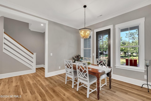 dining area with a chandelier, light hardwood / wood-style flooring, and crown molding