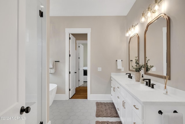 bathroom with vanity, a tub, and tile patterned floors