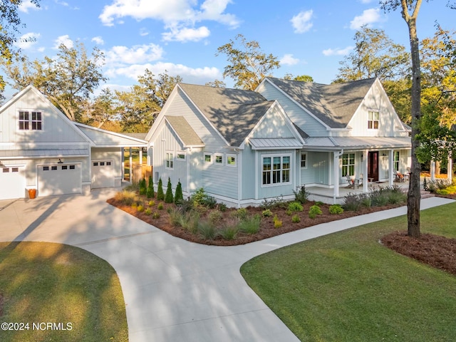 view of front of property featuring a front yard, a porch, and a garage