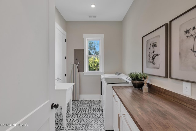 clothes washing area with cabinets, electric panel, and washing machine and dryer