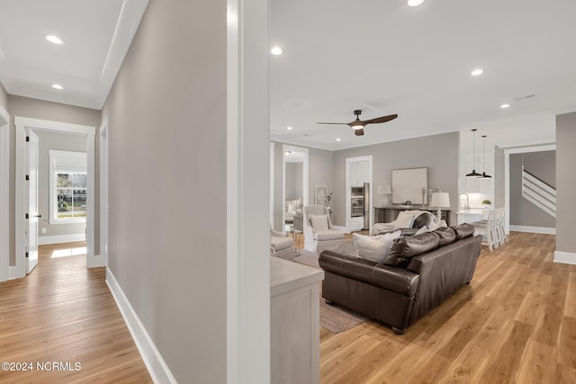 living room featuring light wood-type flooring and ceiling fan