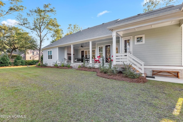 view of front of property with ceiling fan and a front yard