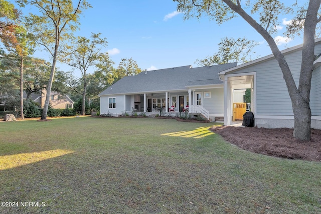 back of house featuring a lawn and a porch