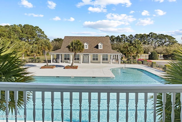 view of swimming pool with a water view and a patio