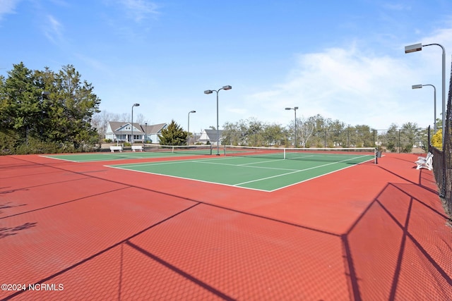 view of tennis court featuring basketball hoop