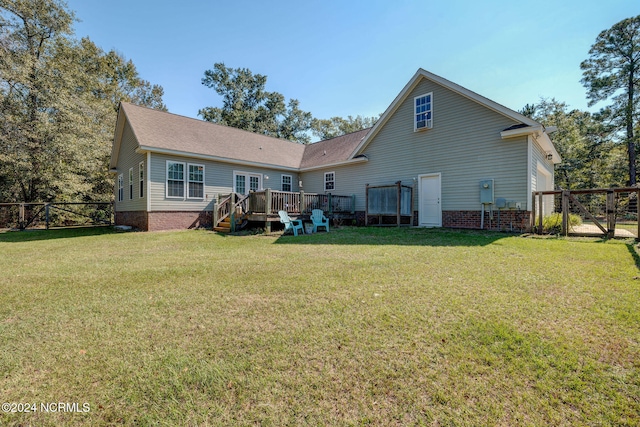 rear view of property with a deck and a yard