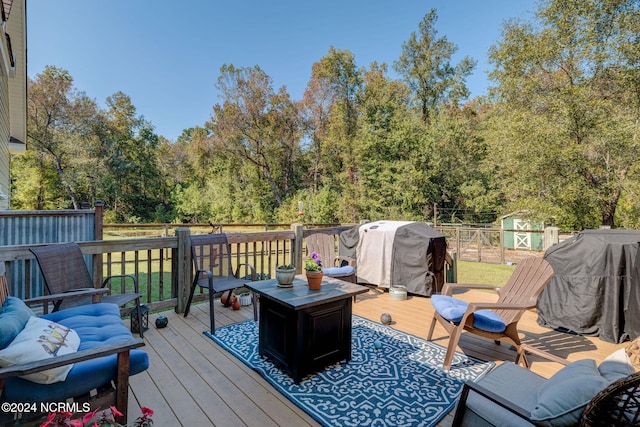 wooden deck featuring a shed and a grill