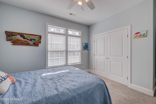 carpeted bedroom featuring a closet and ceiling fan