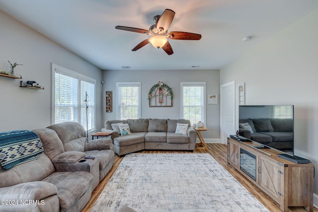 living room featuring light hardwood / wood-style flooring, a healthy amount of sunlight, and ceiling fan