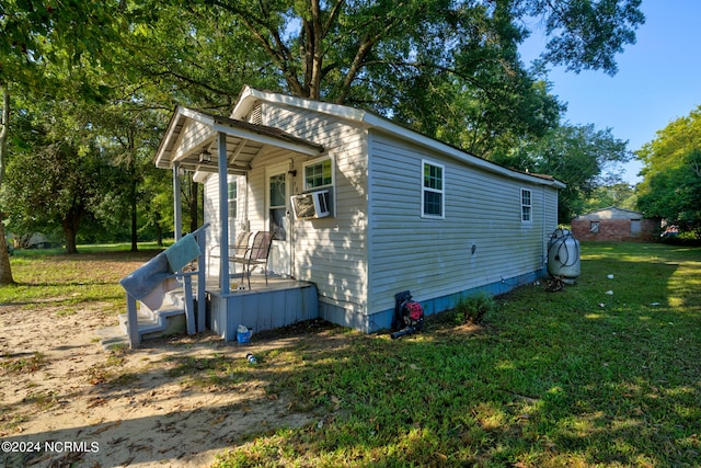 view of side of home featuring cooling unit and a lawn