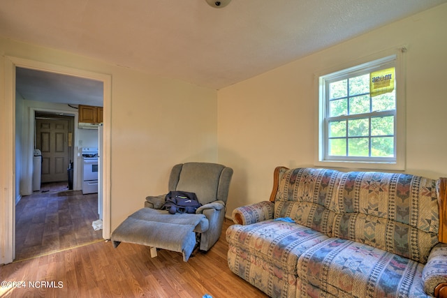 living area with washer / dryer and hardwood / wood-style flooring