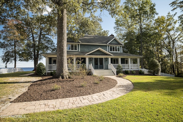 view of front facade featuring a front yard, covered porch, and a water view