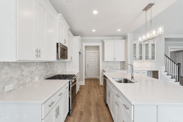 kitchen featuring white cabinetry, hanging light fixtures, stainless steel appliances, and sink