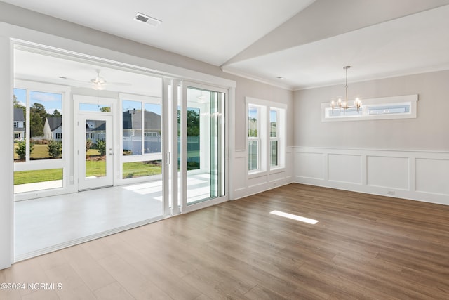 empty room with crown molding, wood-type flooring, and ceiling fan with notable chandelier