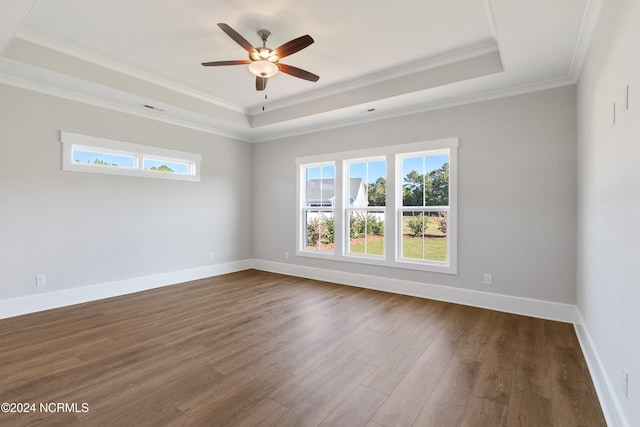 spare room with ceiling fan, a raised ceiling, ornamental molding, and dark hardwood / wood-style floors