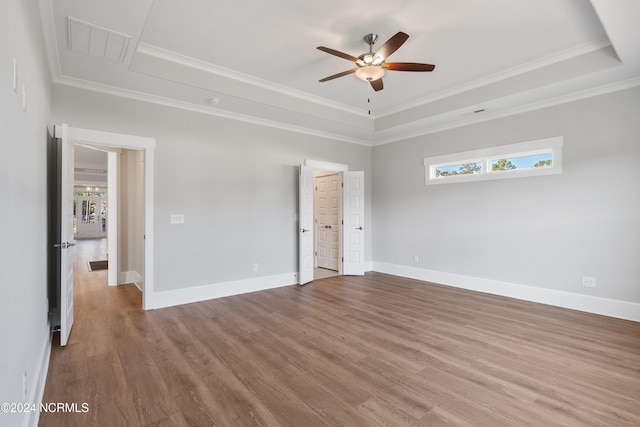 spare room with hardwood / wood-style floors, a tray ceiling, and a wealth of natural light