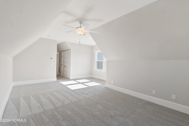 additional living space with lofted ceiling, light carpet, and ceiling fan