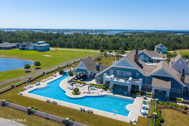 view of pool with a patio, a water view, and a yard