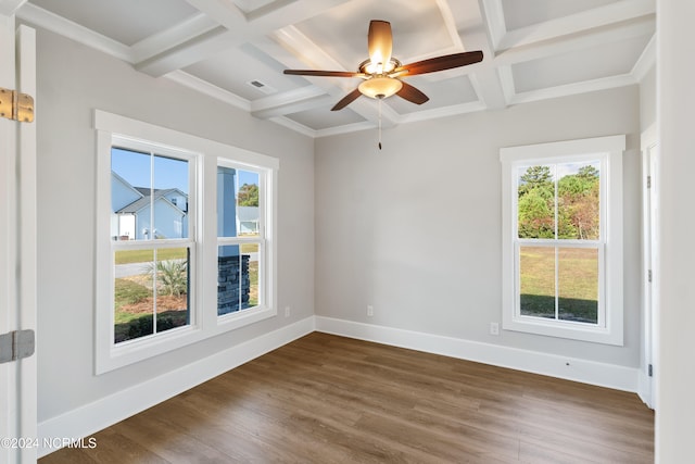 empty room with coffered ceiling, plenty of natural light, and dark hardwood / wood-style floors