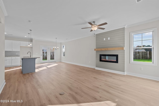 unfurnished living room with plenty of natural light, crown molding, and sink