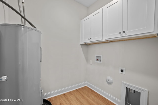 clothes washing area with cabinets, washer hookup, hookup for an electric dryer, gas dryer hookup, and light hardwood / wood-style floors