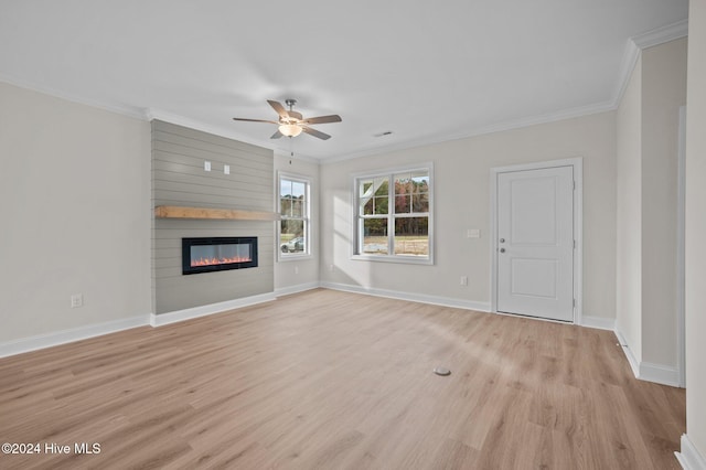 unfurnished living room featuring a large fireplace, light hardwood / wood-style floors, ceiling fan, and ornamental molding