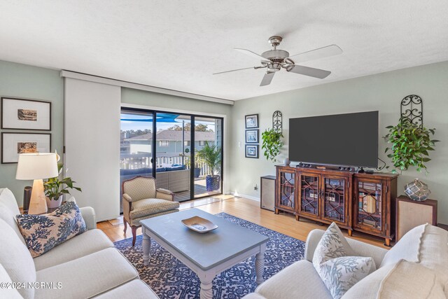 dining space featuring light wood-type flooring, a textured ceiling, and ceiling fan