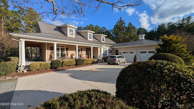 new england style home featuring a porch and a garage