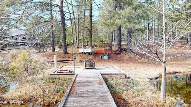 view of yard featuring a deck with water view and a fire pit