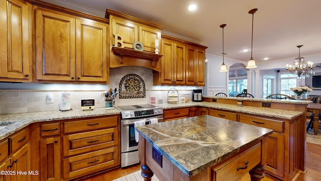 kitchen with tasteful backsplash, ornamental molding, a kitchen island, and stainless steel range with electric stovetop