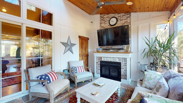 interior space with wood ceiling, ceiling fan, a fireplace, and vaulted ceiling