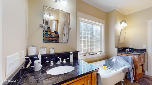 bathroom with vanity, ornamental molding, and a tub