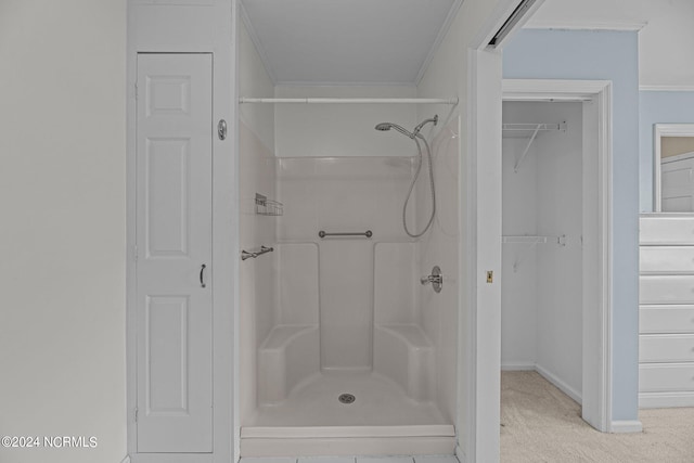 bathroom featuring ornamental molding and walk in shower