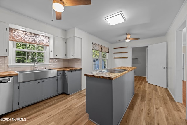 kitchen featuring dishwasher, butcher block counters, sink, and a wealth of natural light