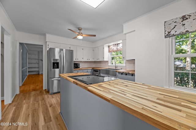 kitchen with white cabinets, backsplash, light wood-type flooring, black appliances, and wooden counters