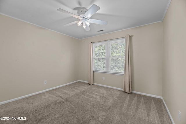 empty room with crown molding, light carpet, and ceiling fan